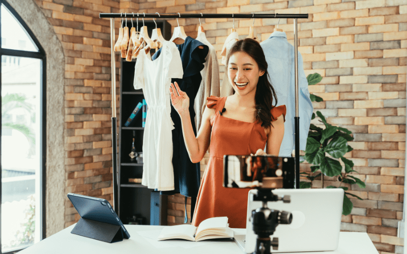 An Influencer marketing consultant showing off a rack of clothes from a brand