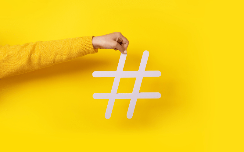 an arm holding up a social media marketing hashtag